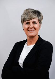 Porträtfoto eines weiblichen Teammitglieds mit kurzem grauem Haar.